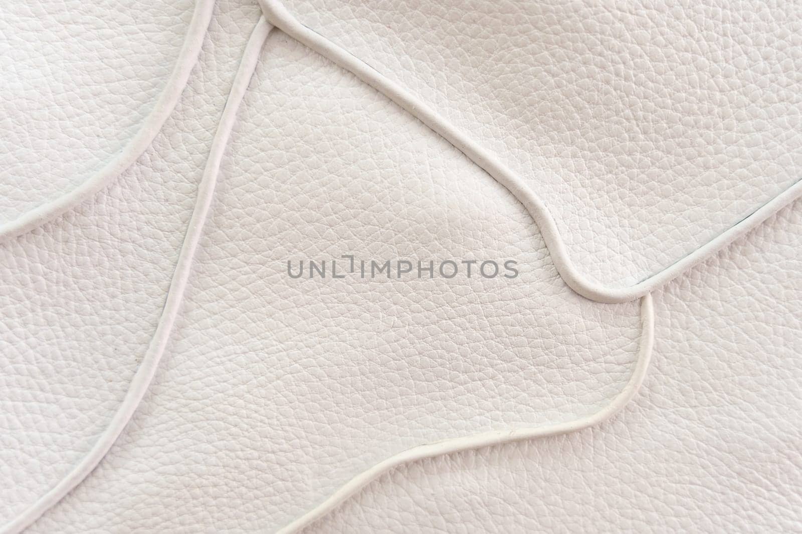 White leather texture with patterned stitching, used as a luxurious classic background. Texture and backgrounds