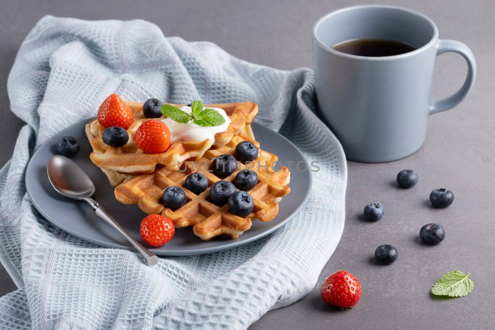 Delicious waffles with whipped cream, strawberries and blueberries.