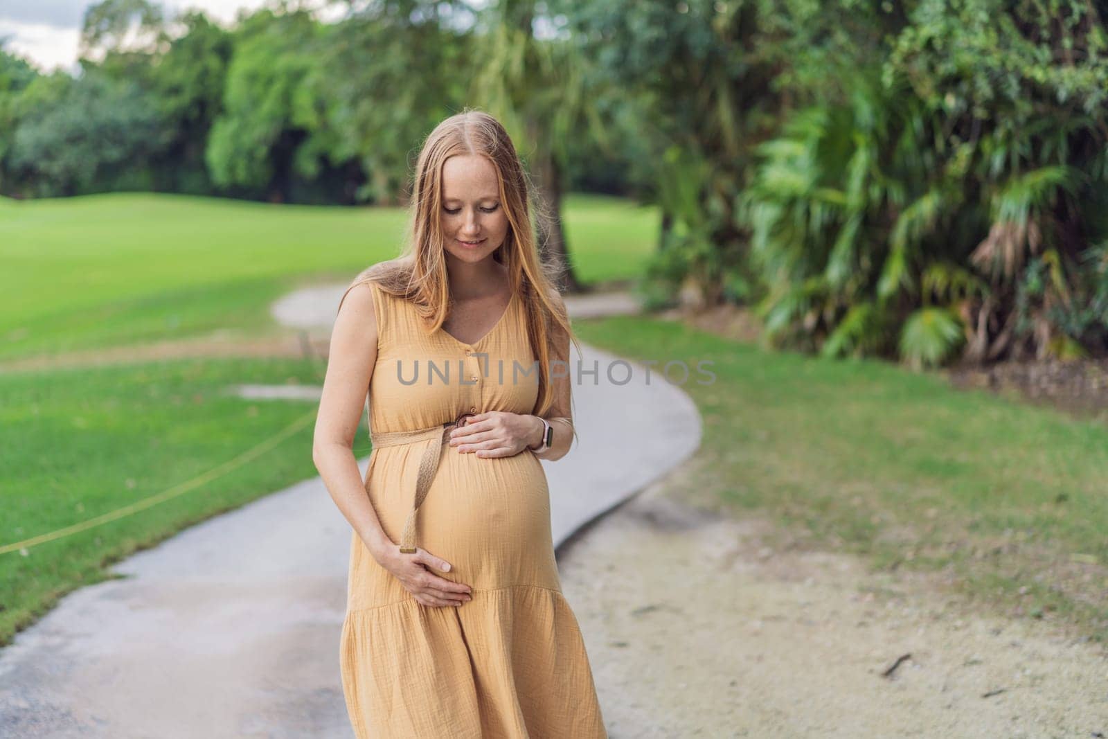 Tranquil scene as a pregnant woman enjoys peaceful moments in the park, embracing nature's serenity and finding comfort during her pregnancy by galitskaya