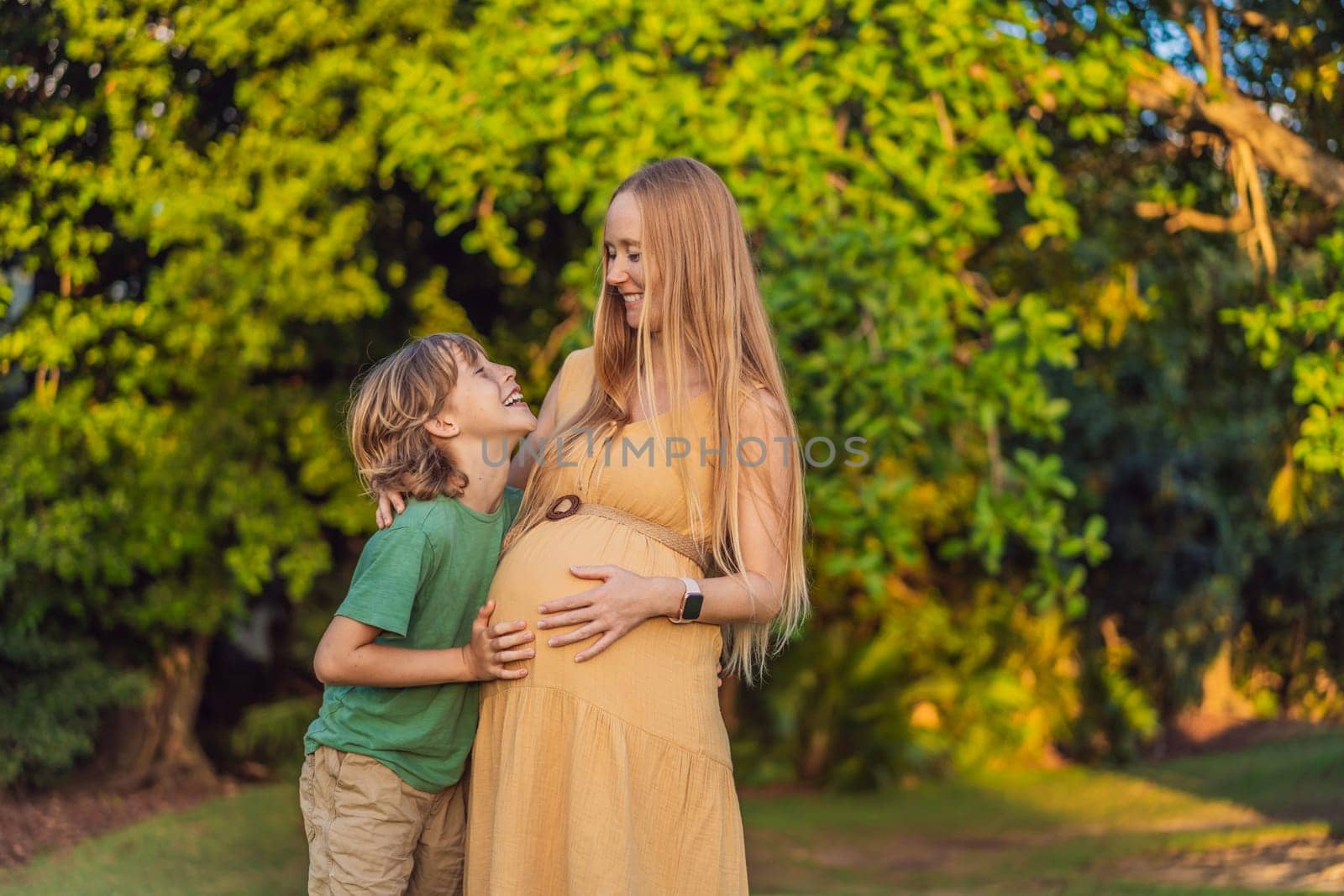 Heartwarming outdoor bonding as a pregnant mom and her son enjoy quality time together, savoring the beauty of nature and creating cherished moments by galitskaya