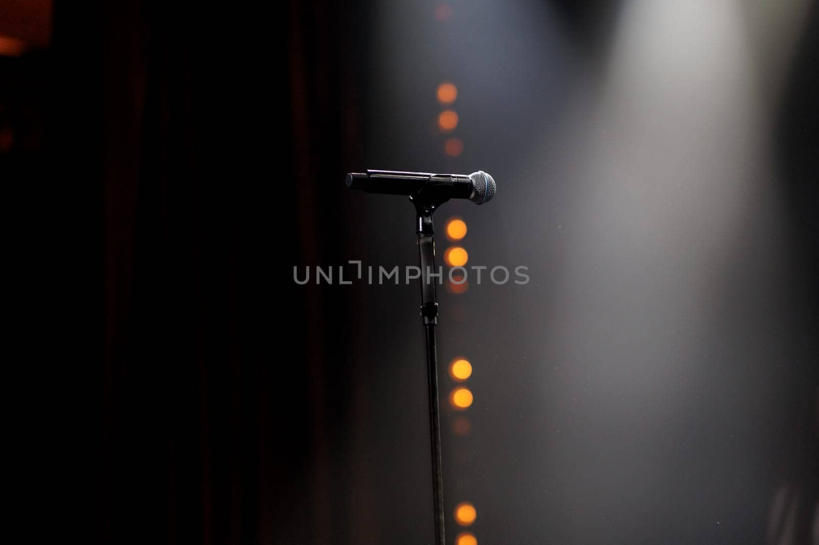microphone on the stand on the stage backlight dark background. High quality photo