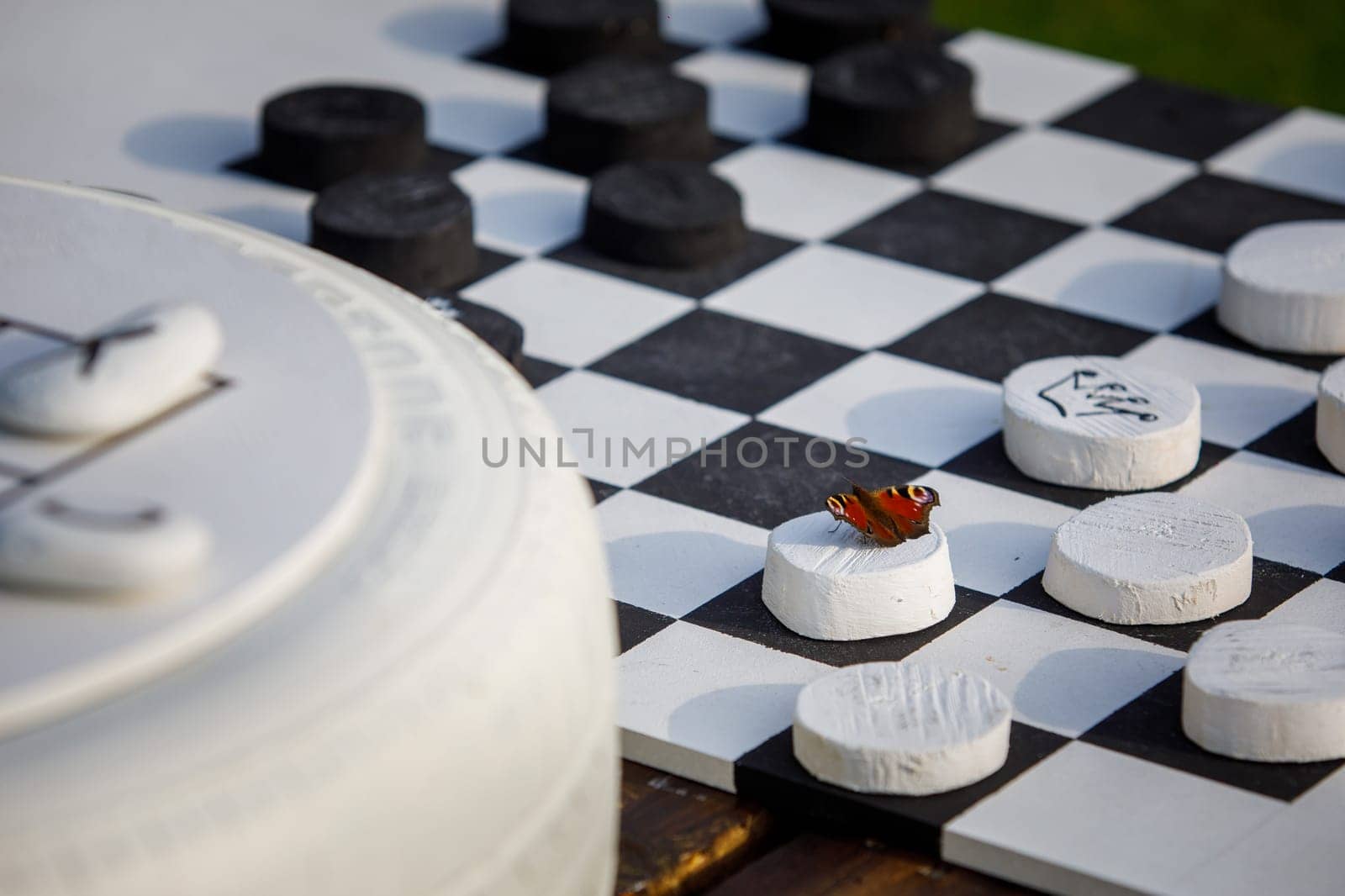 a chessboard and a red butterfly sitting on a pawn. High quality photo