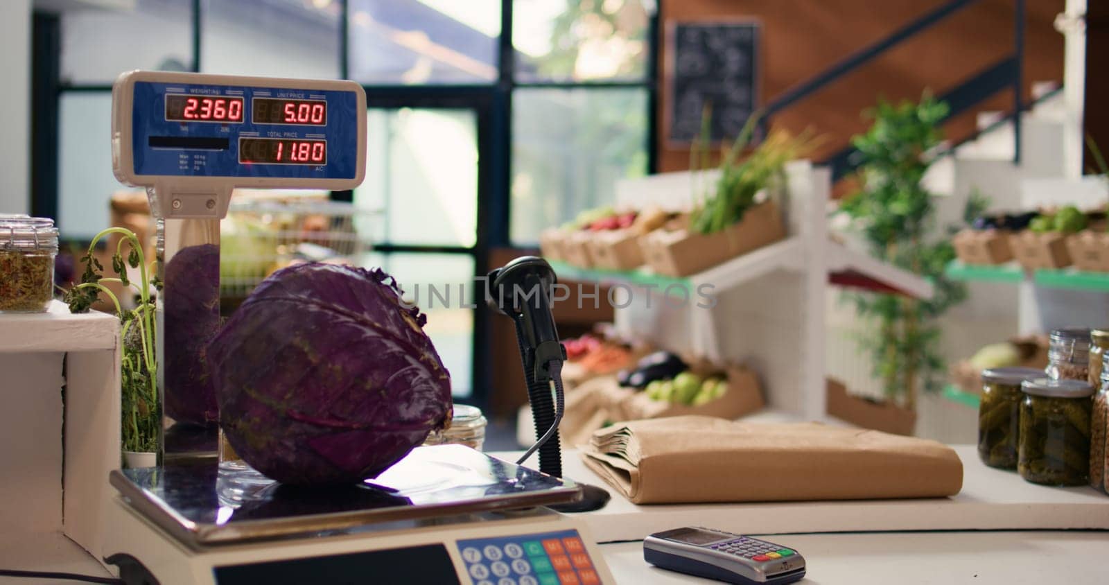 Electronic scale in eco friendly store next to organic locally grown produce. Modern weighing machine used in local neighborhood shop for bulk products and fruits or vegetables.