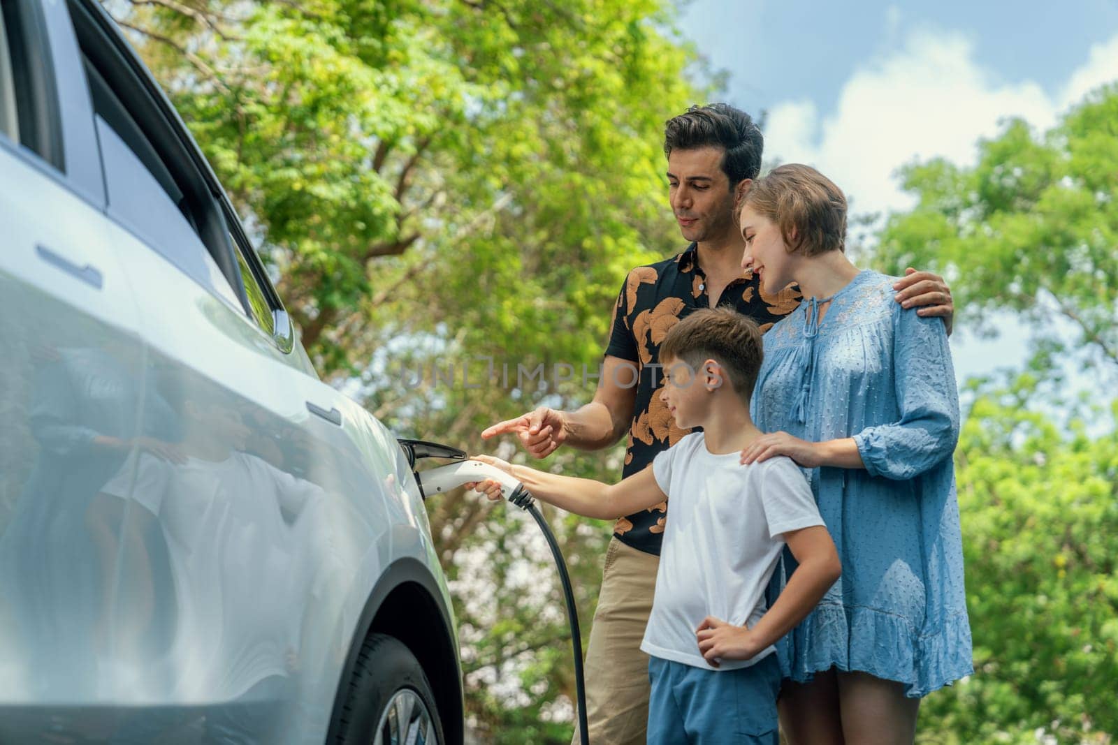 Family road trip vacation with electric vehicle, lovely family recharge EV car with green and clean energy. Natural and eco friendly car travel for sustainable environment. Perpetual