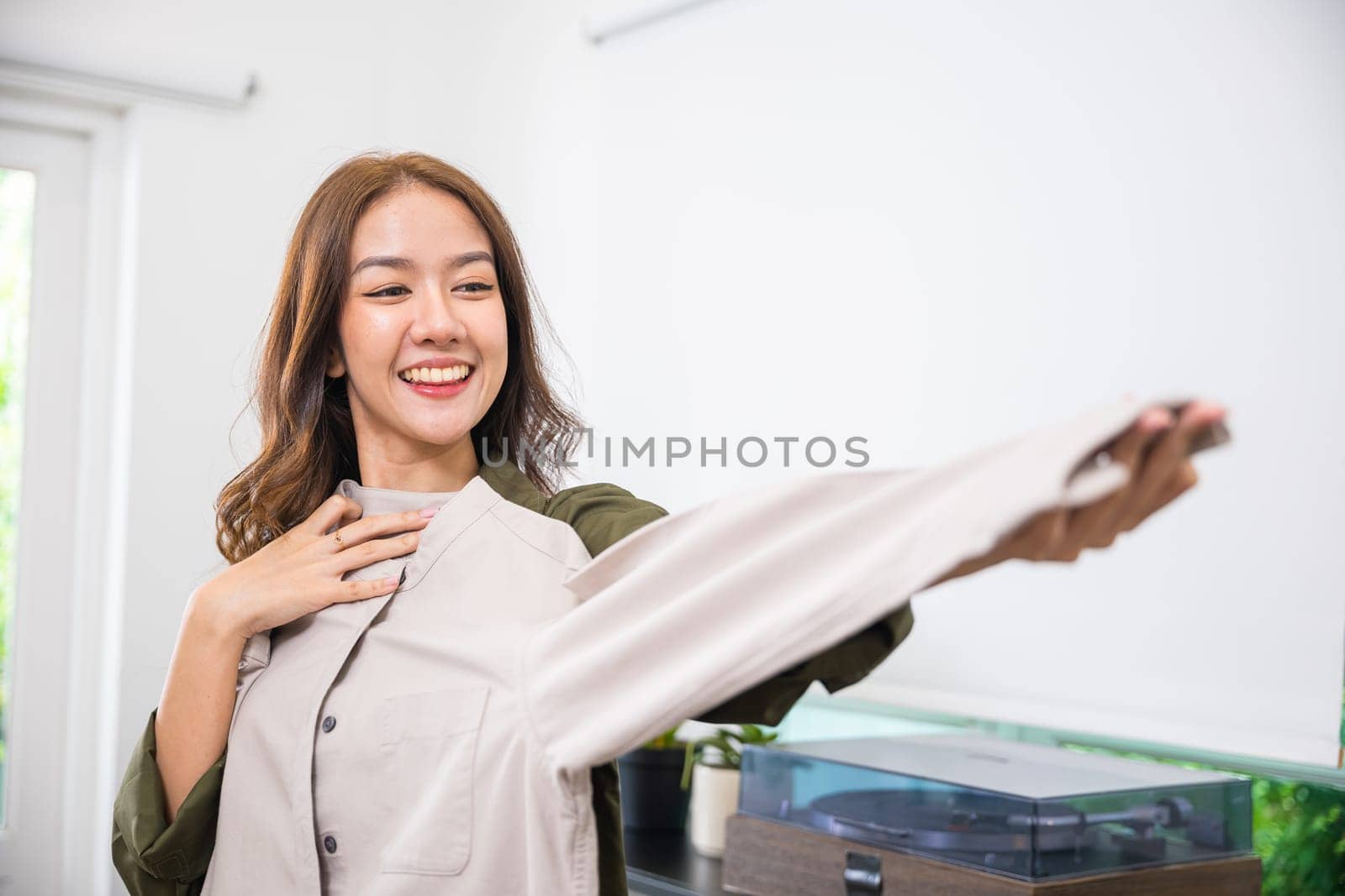 Happy Asian woman customer opening box and shirt against body new clothes, Excited smiling female shopper unboxing cardboard box package, shopping online from home, delivery shipping concept