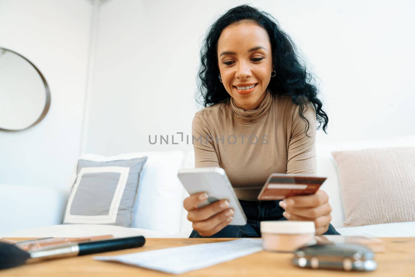 Young happy woman buy product by online shopping at home while ordering items from the internet with credit card online payment system protected by crucial cyber security from online store platform