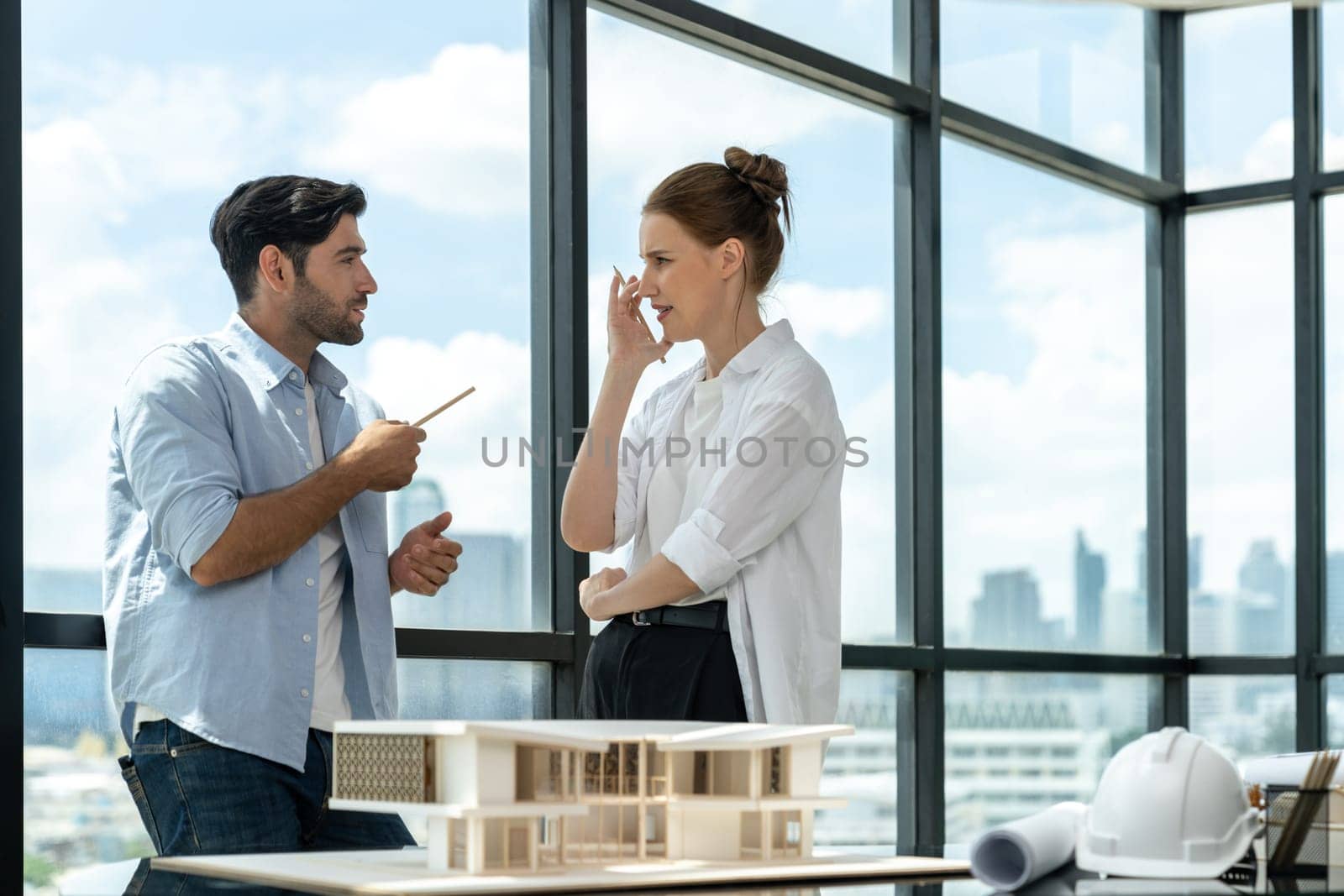 Professional architect engineer team discussing about house construction. Expert businesspeople sharing and brainstorming idea about house design. Working together. Skyscraper. Tracery.