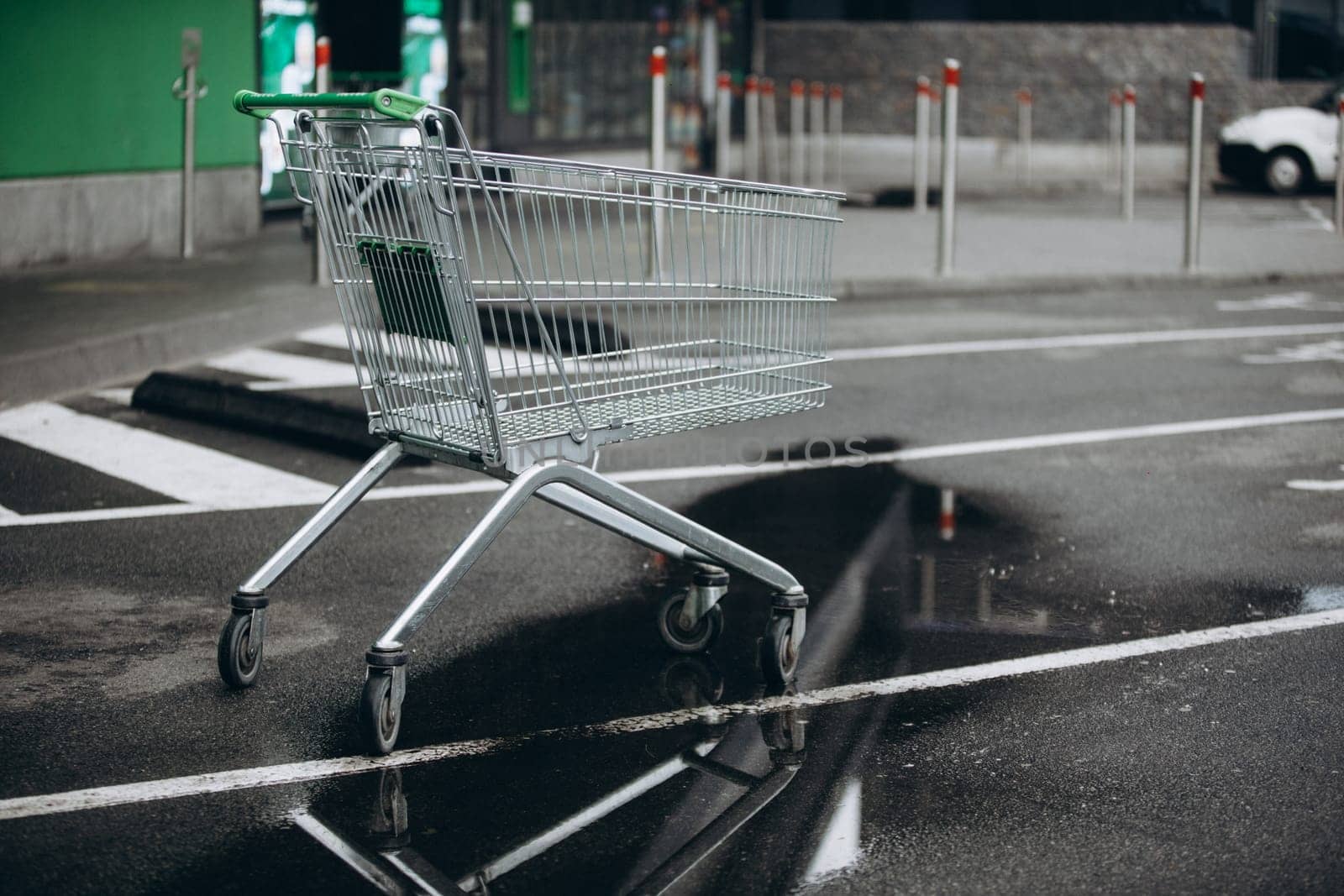 a supermarket basket is on the asvalt and a puddle of water, a wheelchair. High quality photo