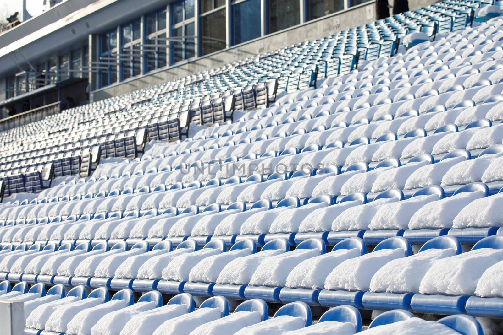 the seats of the stadium stands are covered with snow. High quality photo