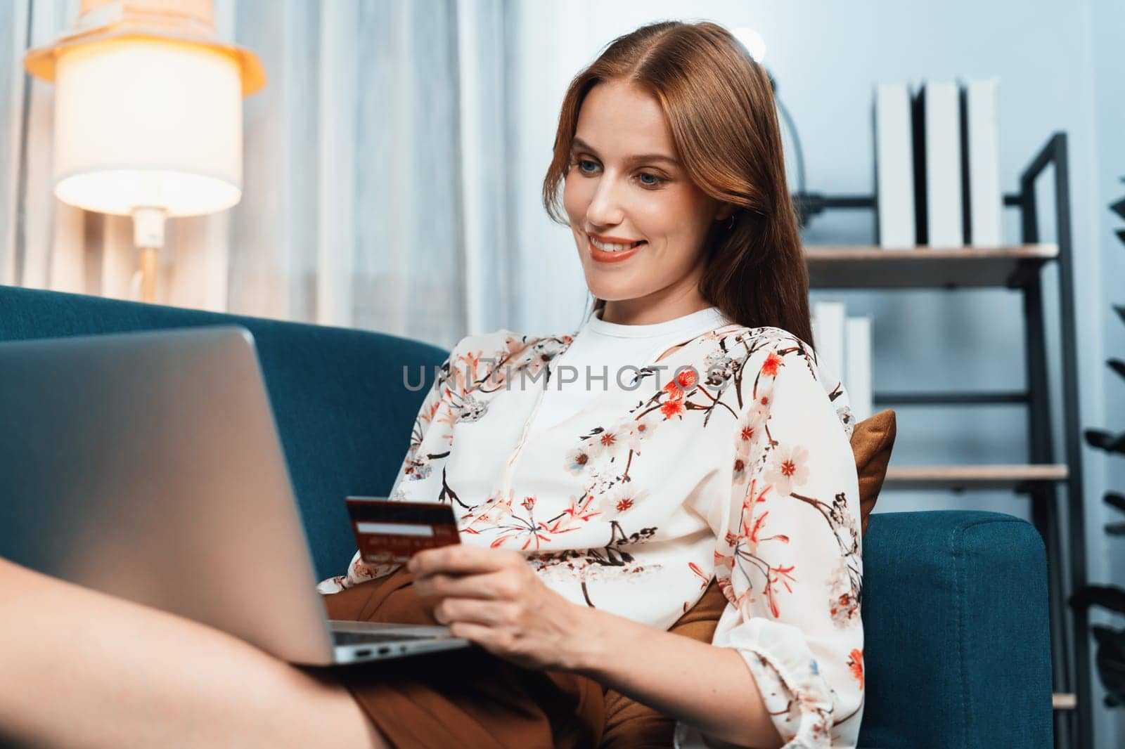 Young happy woman buy product by online shopping at home while ordering items from the internet with credit card online payment system protected by utmost cyber security from online store platform