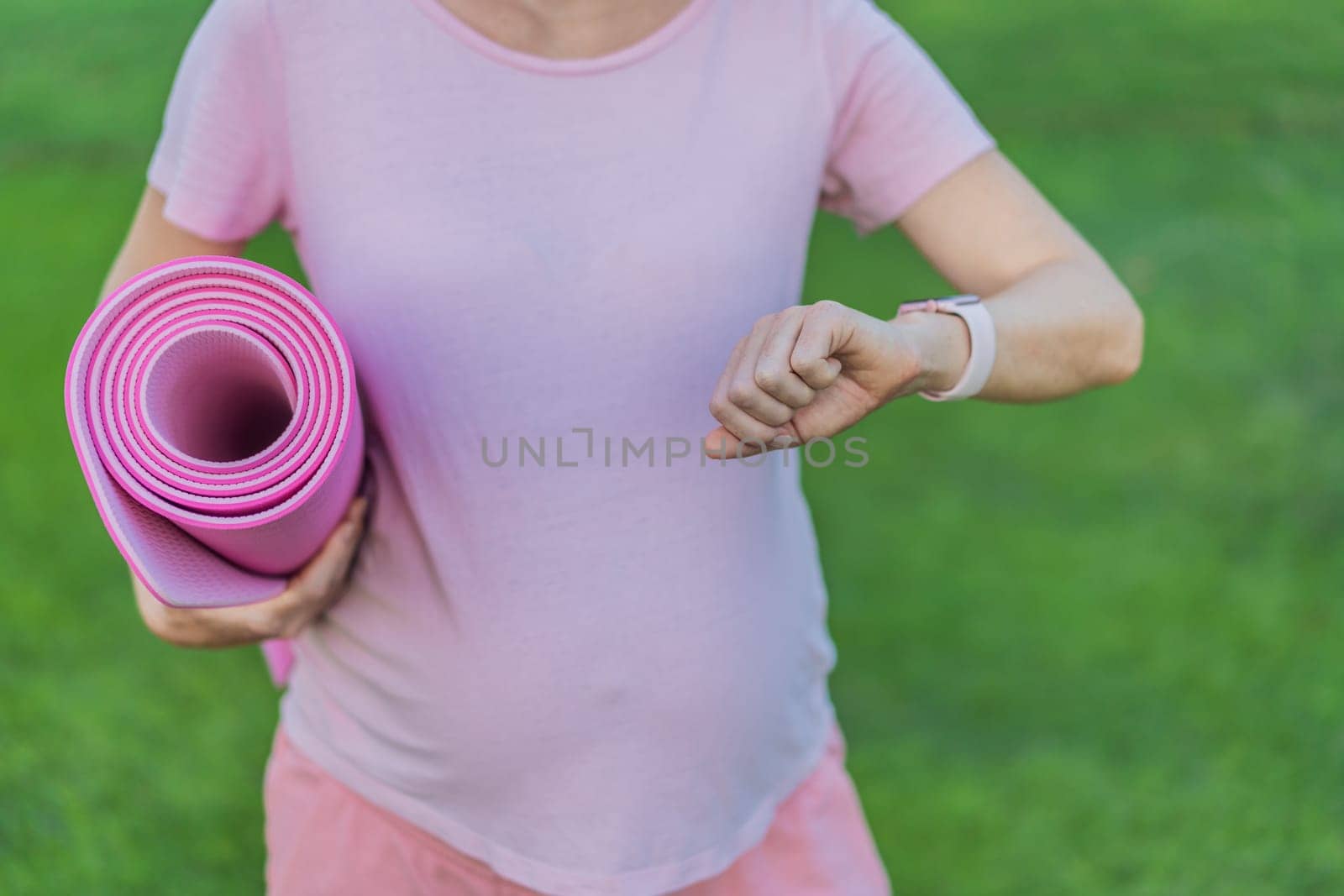 Energetic pregnant woman takes her workout outdoors, using an exercise mat for a refreshing and health-conscious outdoor exercise session by galitskaya