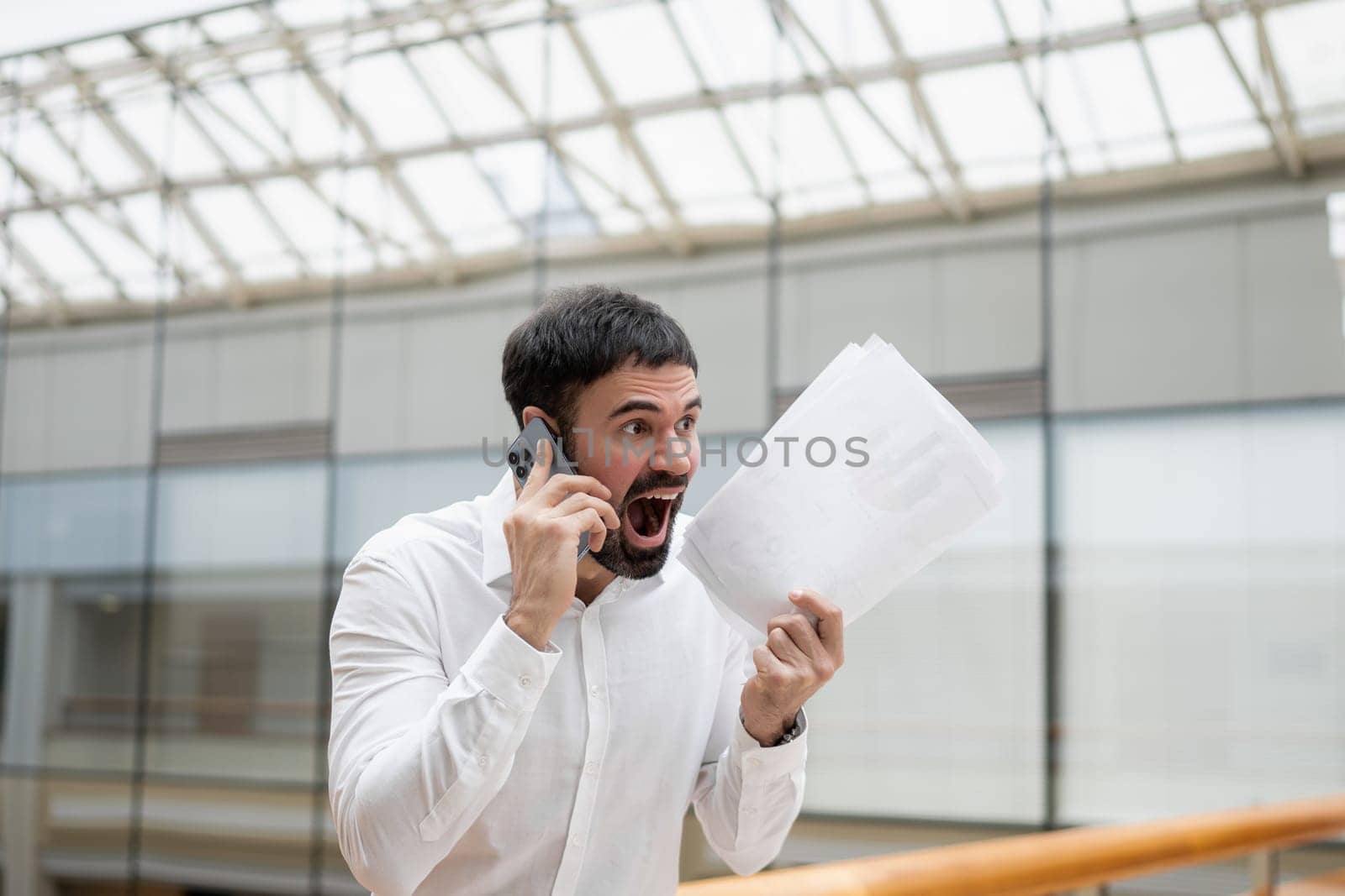 Confident handsome businessman standing in the office. by Сookiestock