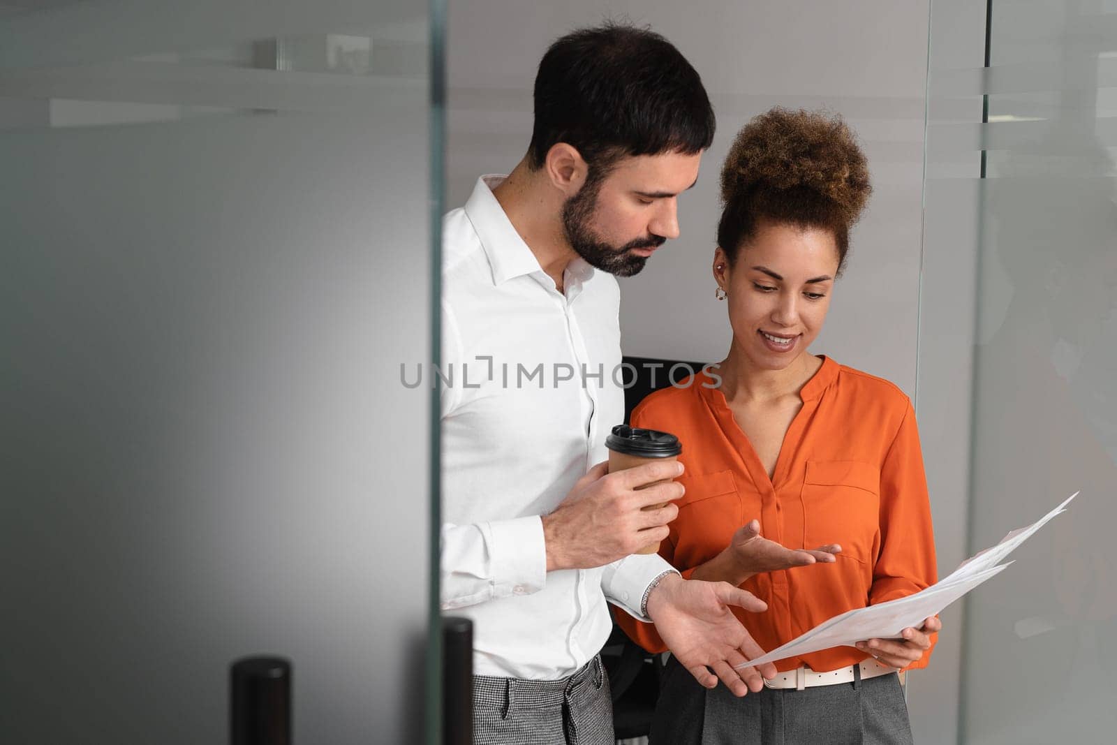 happy businesswoman showing tablet with startup project to asian colleague in modern office.