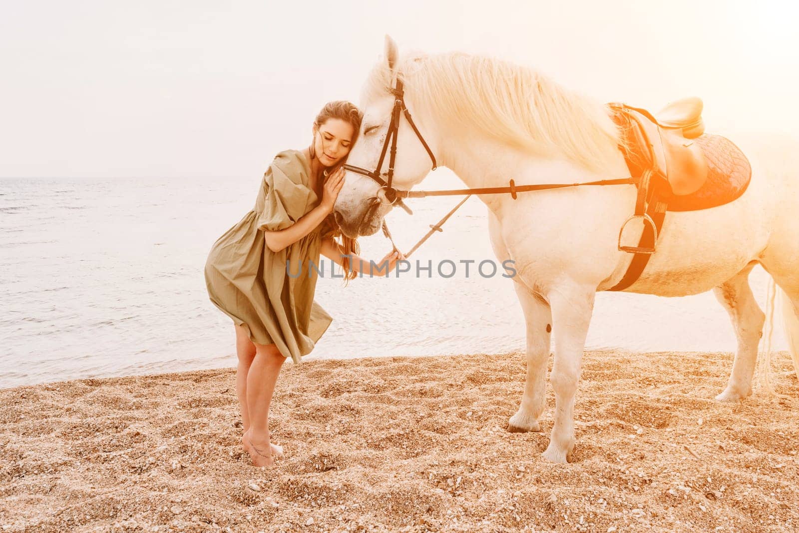 A woman in a dress stands next to a white horse on a beach, with the blue sky and sea in the background. by Matiunina