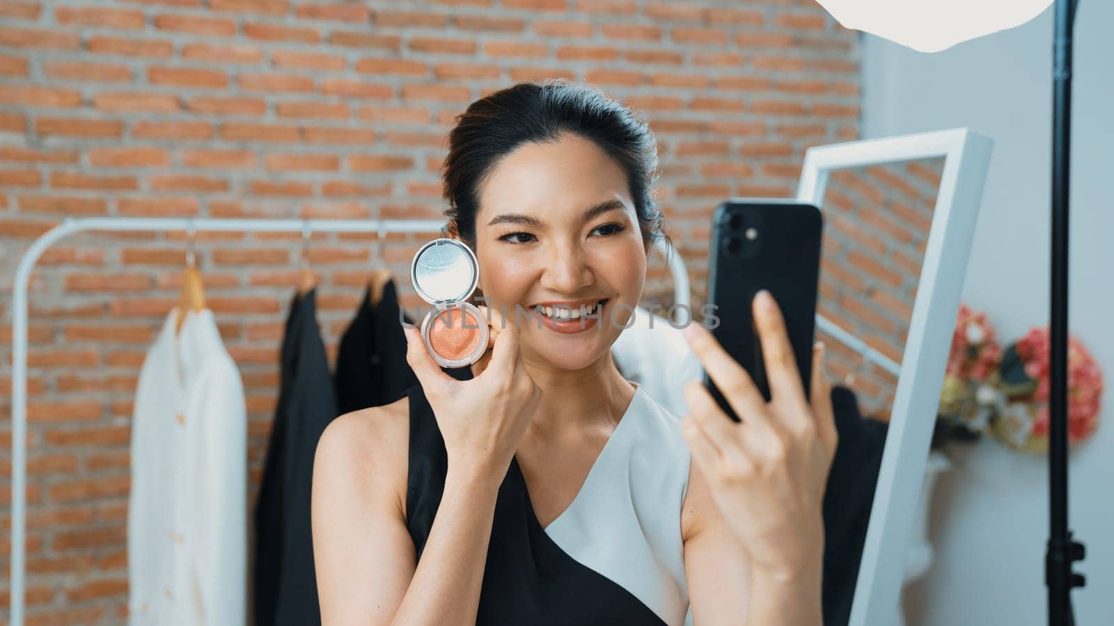 Woman influencer shoot live streaming vlog video review vivancy makeup social media or blog. Happy young girl with cosmetics studio lighting for marketing recording session broadcasting online.