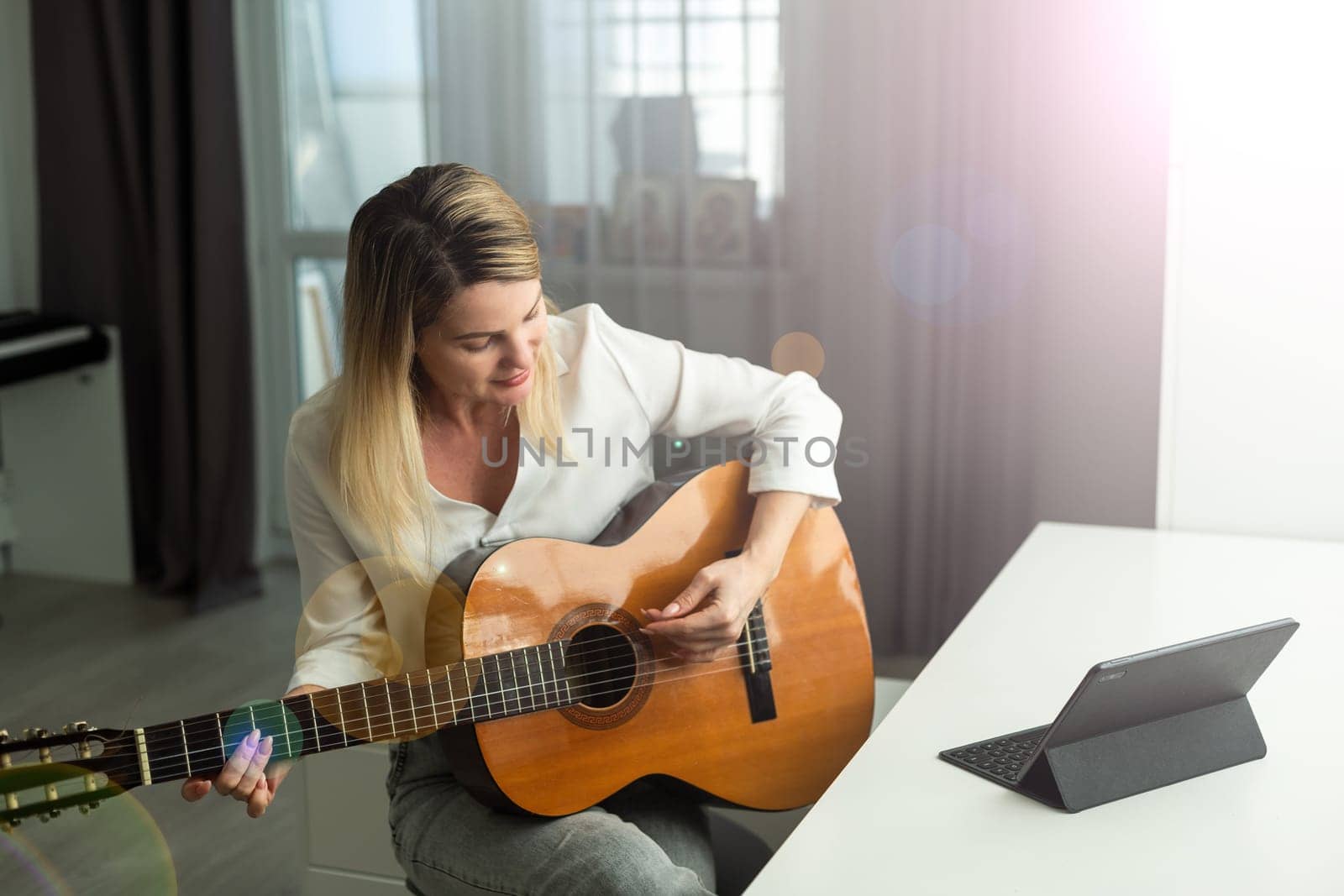 woman blogger live steam playing guitar on social media. High quality photo