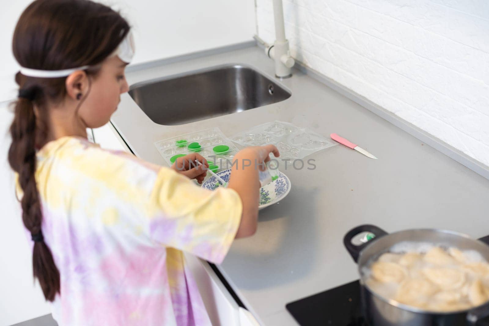 Children are learning and doing science experiments. Little girl playing science experiment for home schooling. Easy and fun science experiments for kids at home. by Andelov13