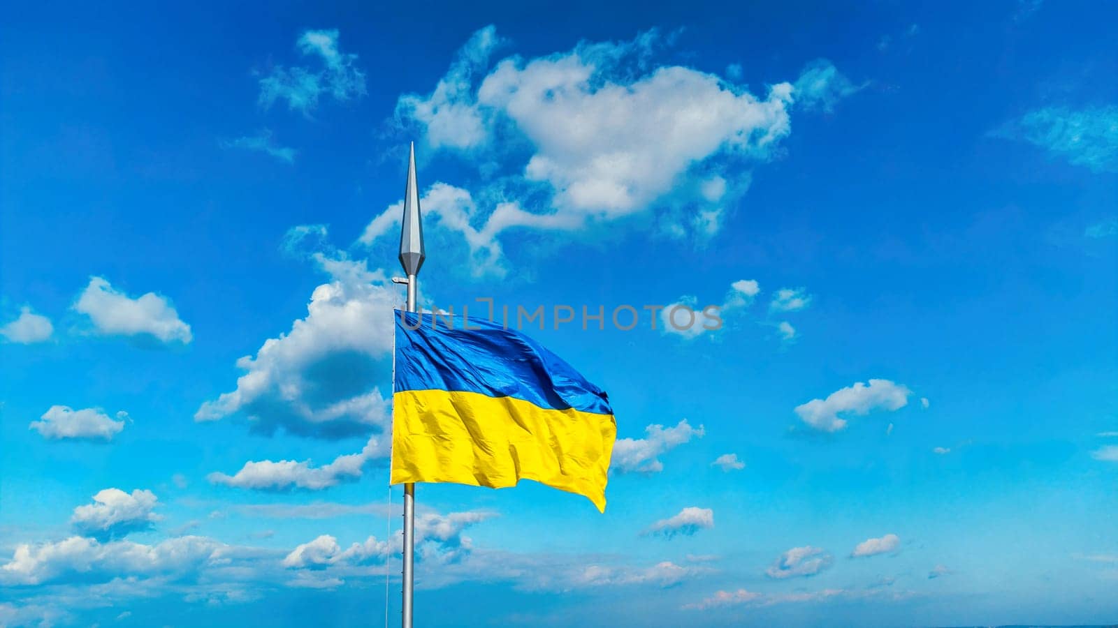 Ukraine flag national symbol waving on blue sky background by igor010