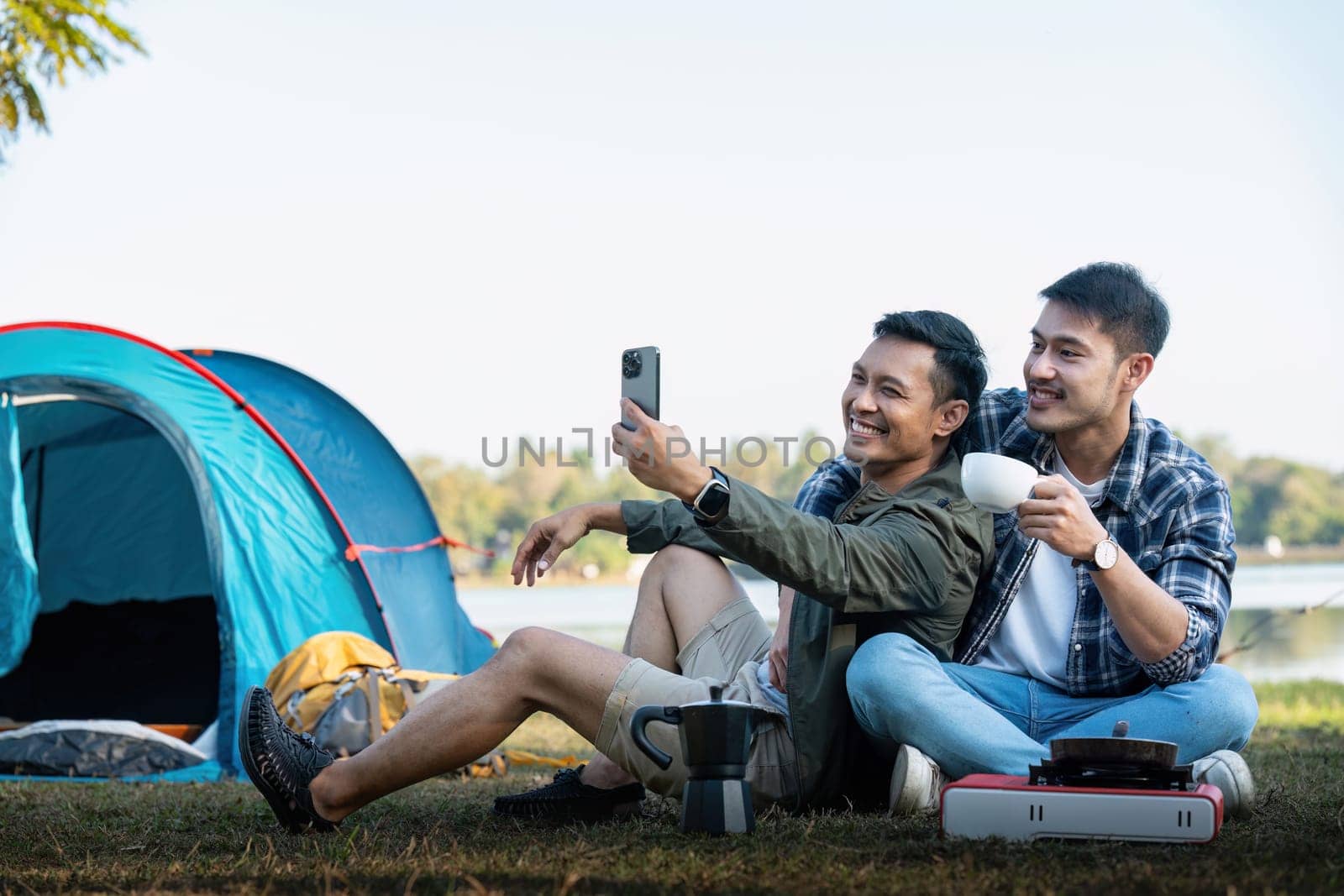 Happy Asian male gay couple on camping together in a forest. romantic vocation trip. lgbt concept.