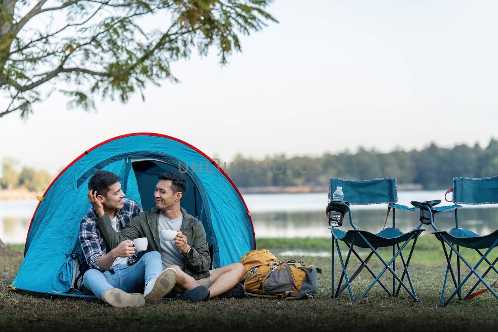 Happy Asian male gay couple on camping together in a forest. romantic vocation trip. lgbt concept by nateemee