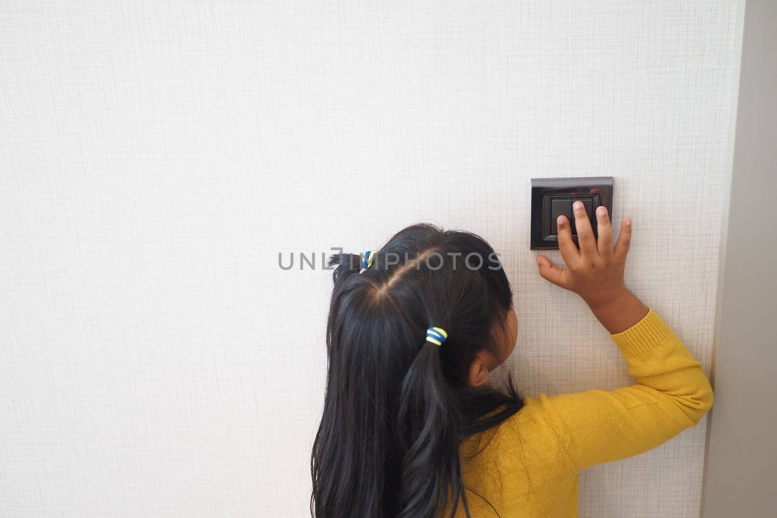 child finger turning on lighting switch with copyspace by towfiq007