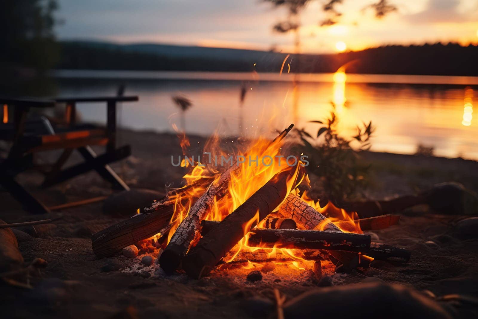 Flaming Campfire at Night: A Bright, Warm Bonfire on a Beach with Red and Orange Flames Reflecting on the Water