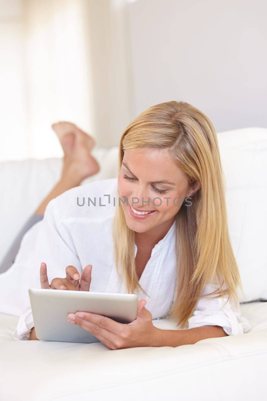 Home, bedroom and woman with a tablet, typing and communication with internet, social media and relax. Person, apartment and girl with technology, connection and digital app with a smile and network by YuriArcurs