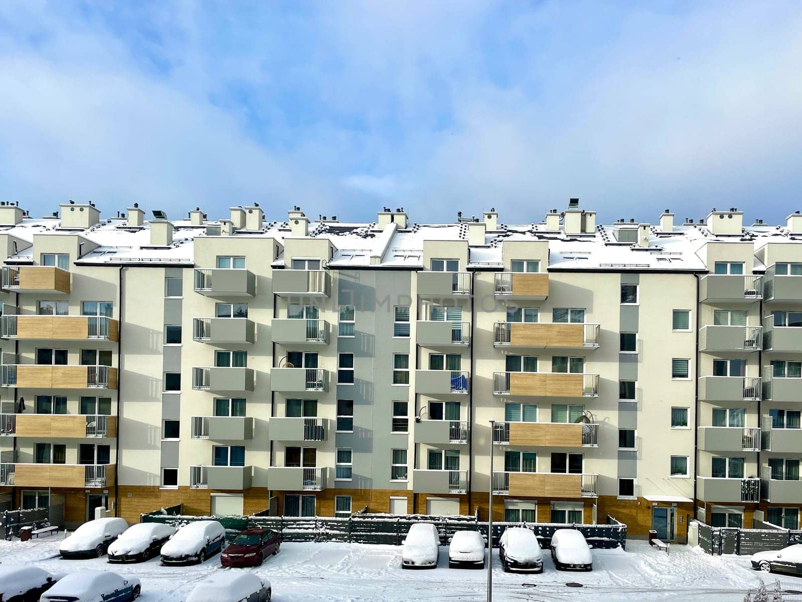 A high-rise building in the city against the background of a blue sky with white clouds. High quality photo