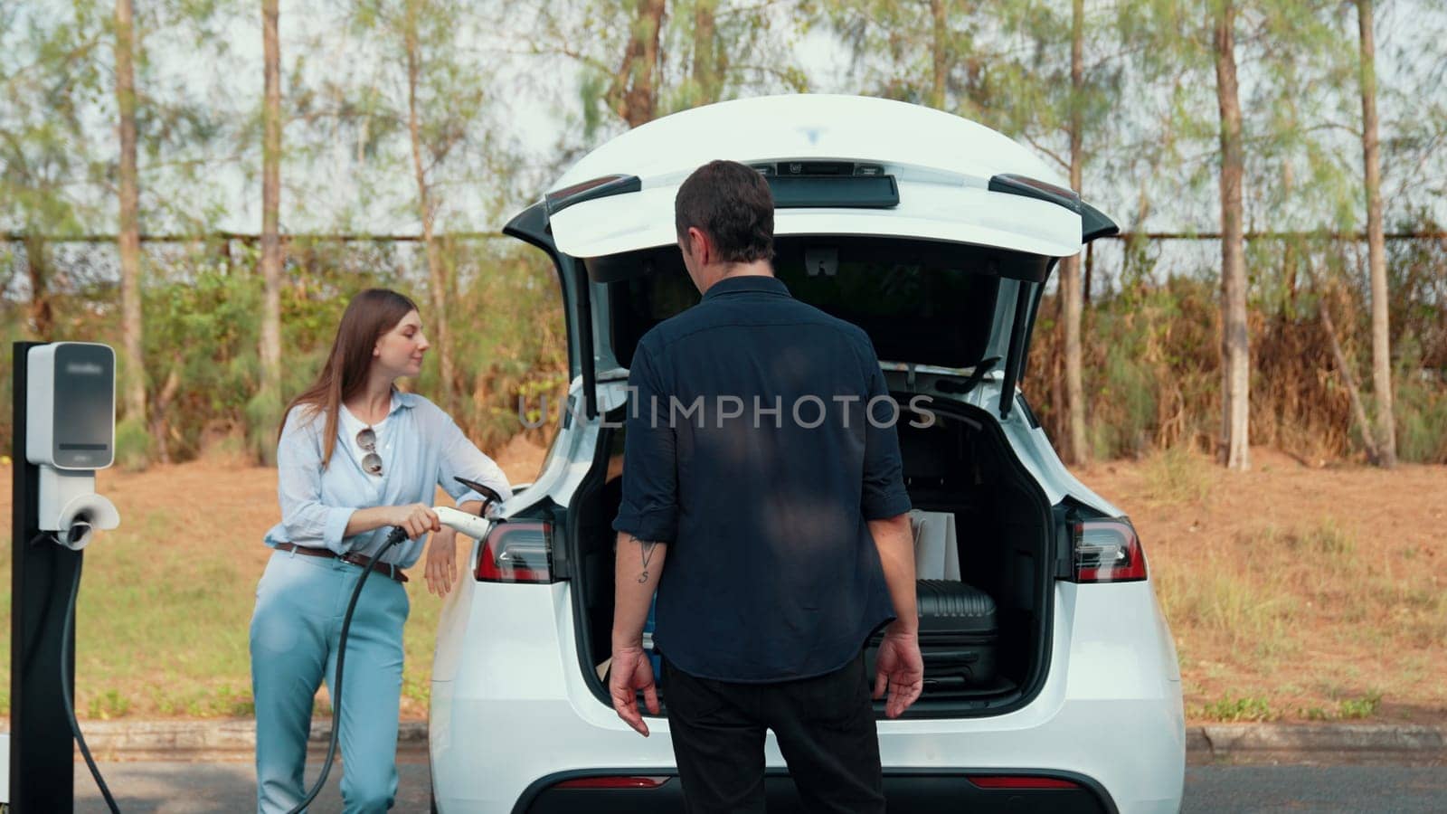 Couple recharge their EV car with electric battery charging station. Exalt by biancoblue