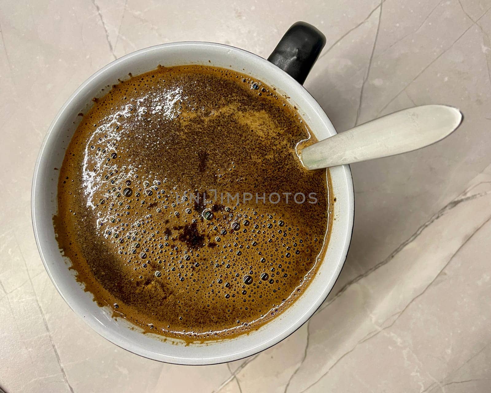 on a gray background, a cup of morning hot coffee and a teaspoon. High quality photo