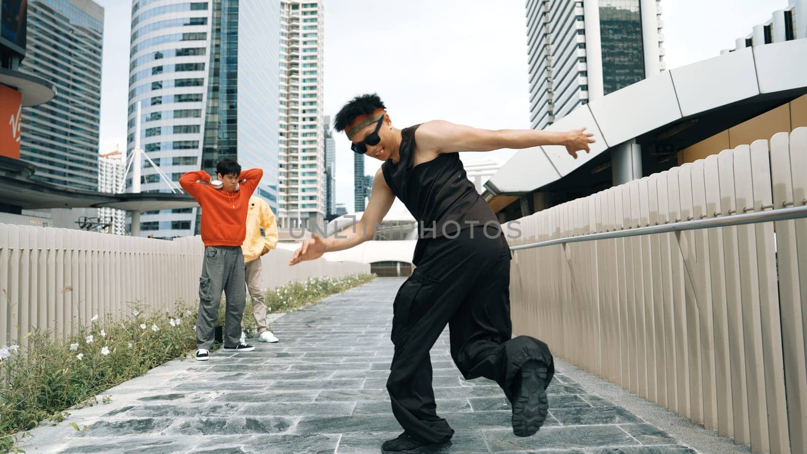 Panorama shot of break dancer perform b-boy performance and energetic footstep at city view. Dancer moving to funky music and cheering young male hipster performance. Outdoor sport 2024. Sprightly.