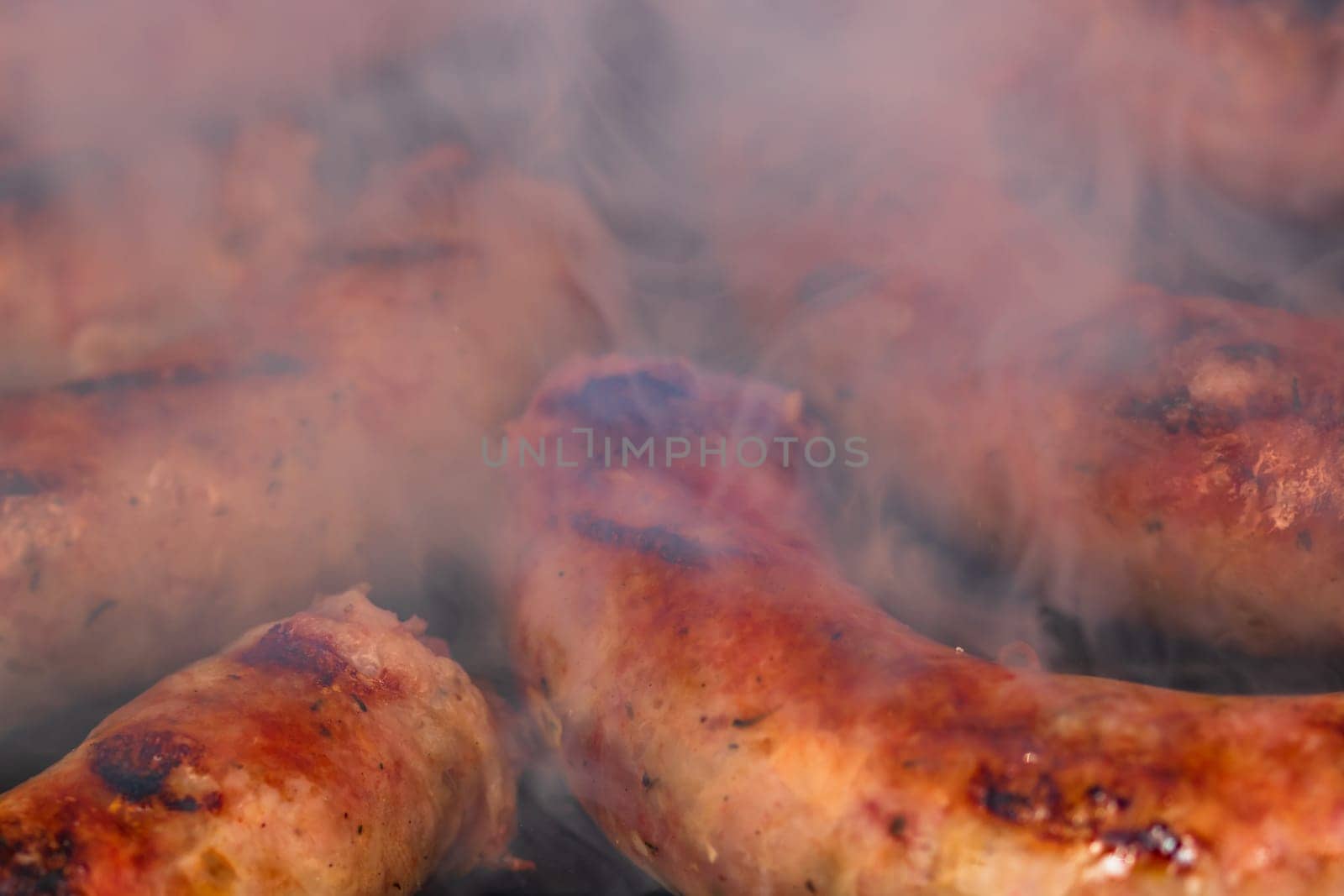 Close up on details of homemade sausages on barbecue grill. Barbecue, grill and food concept. by vladispas