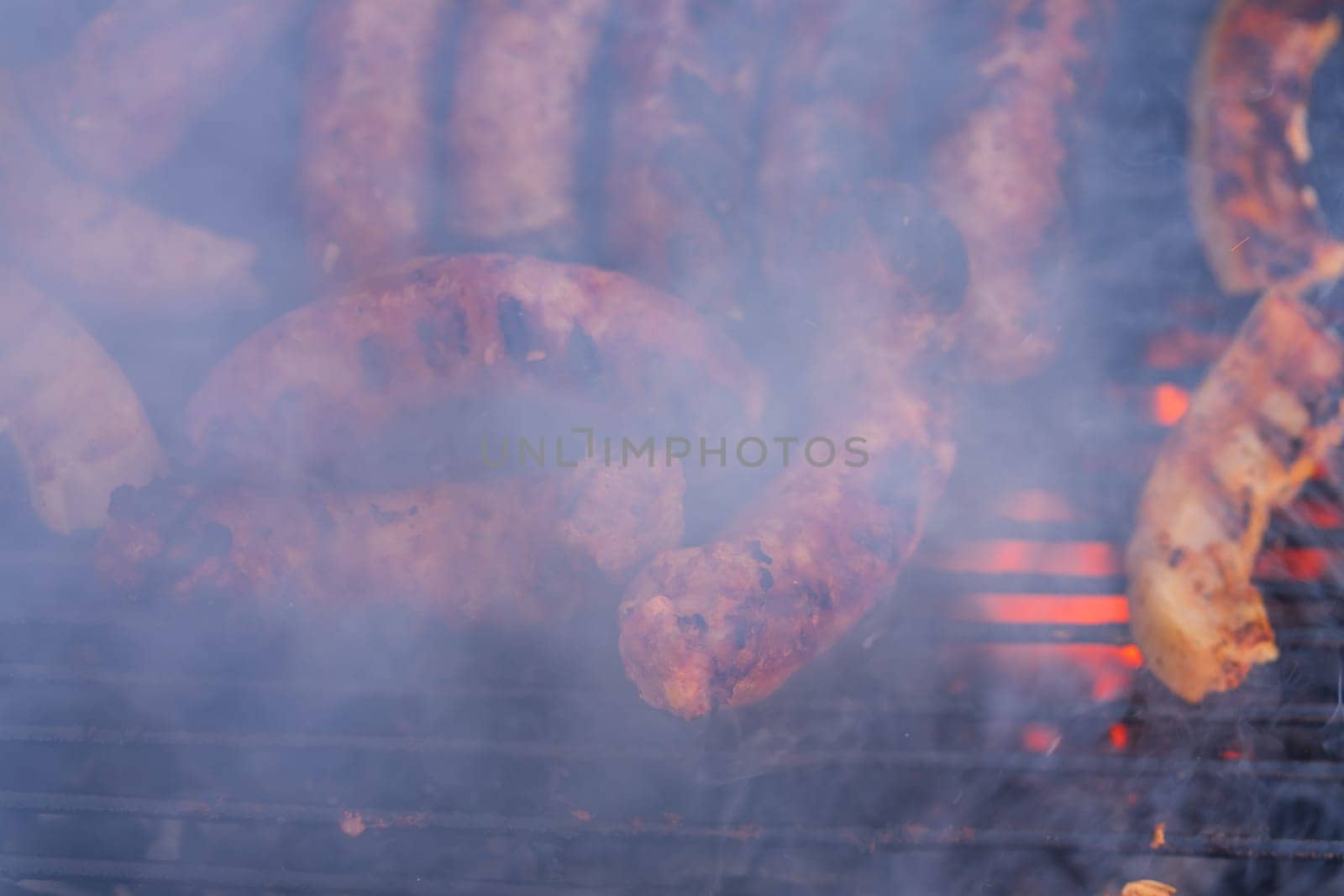 Grilling sausages on barbecue grill. Delicious sausages on charcoal grill