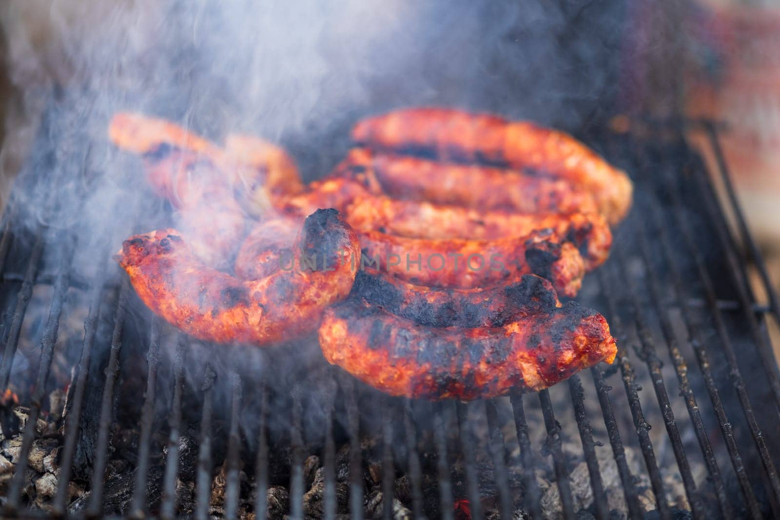 Grilling sausages on barbecue grill. Delicious sausages on charcoal grill