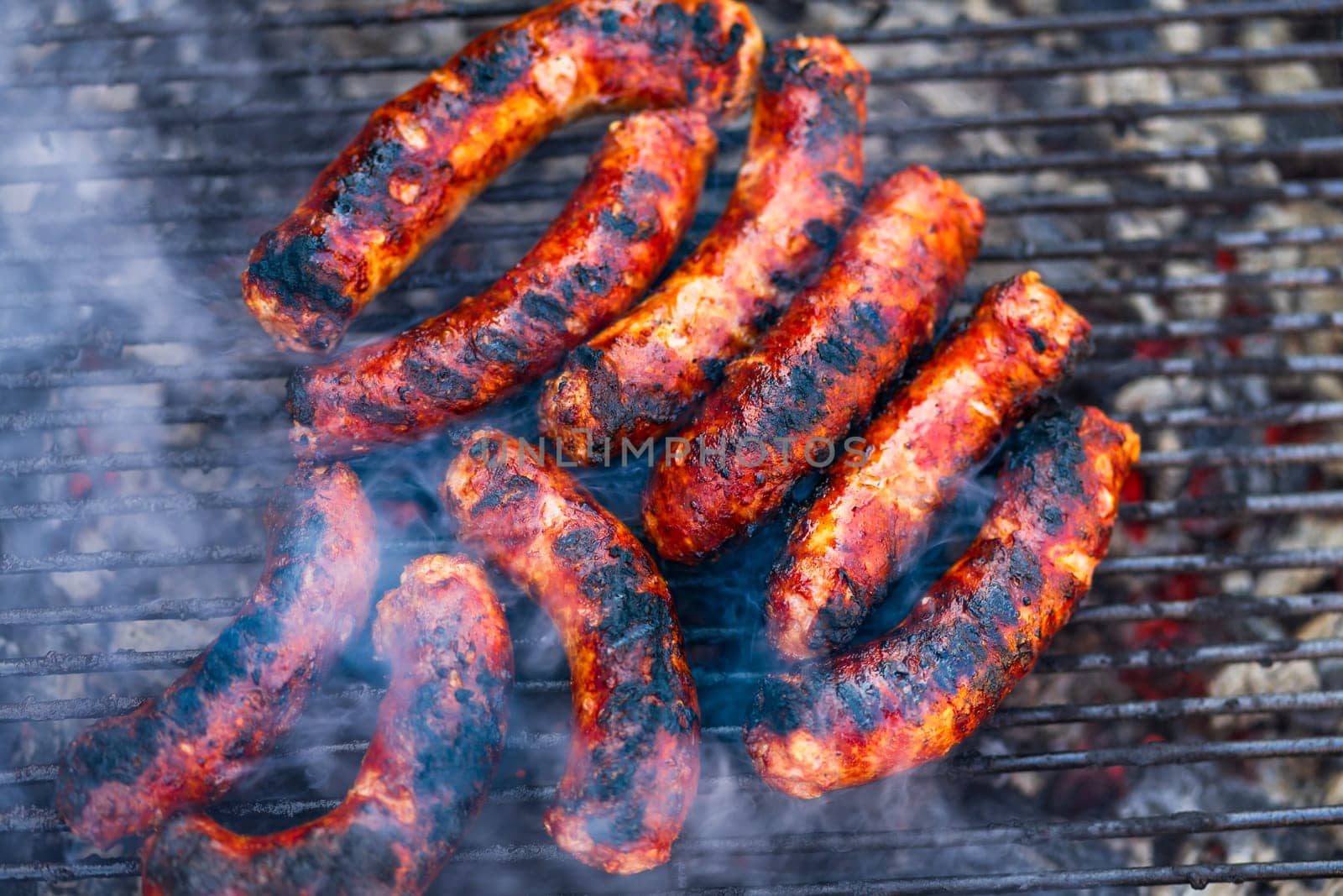 Grilling sausages on barbecue grill. Delicious sausages on charcoal grill