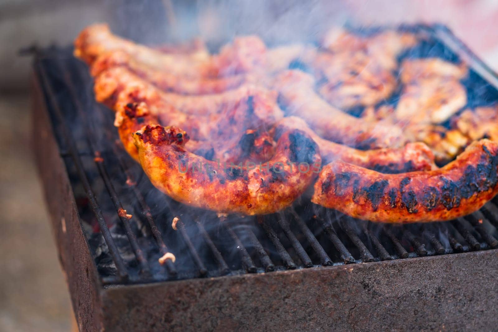 Grilling sausages and pork chops on barbecue grill. BBQ in the garden