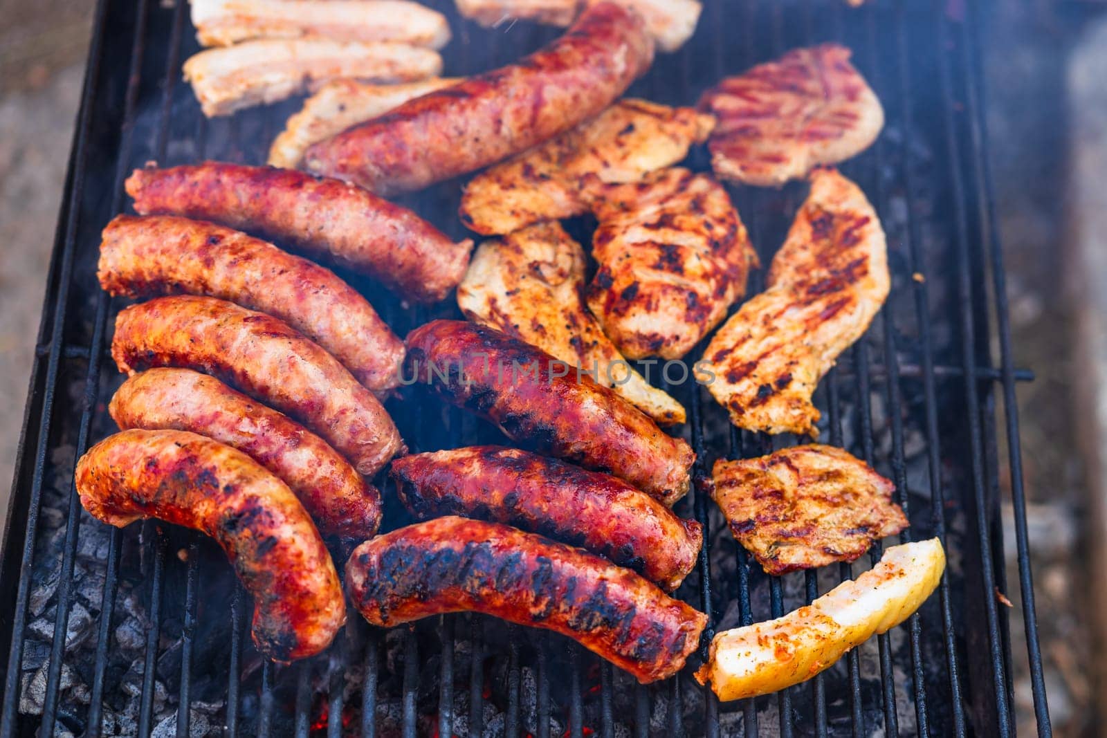 Grilling sausages and pork chops on barbecue grill. BBQ in the garden