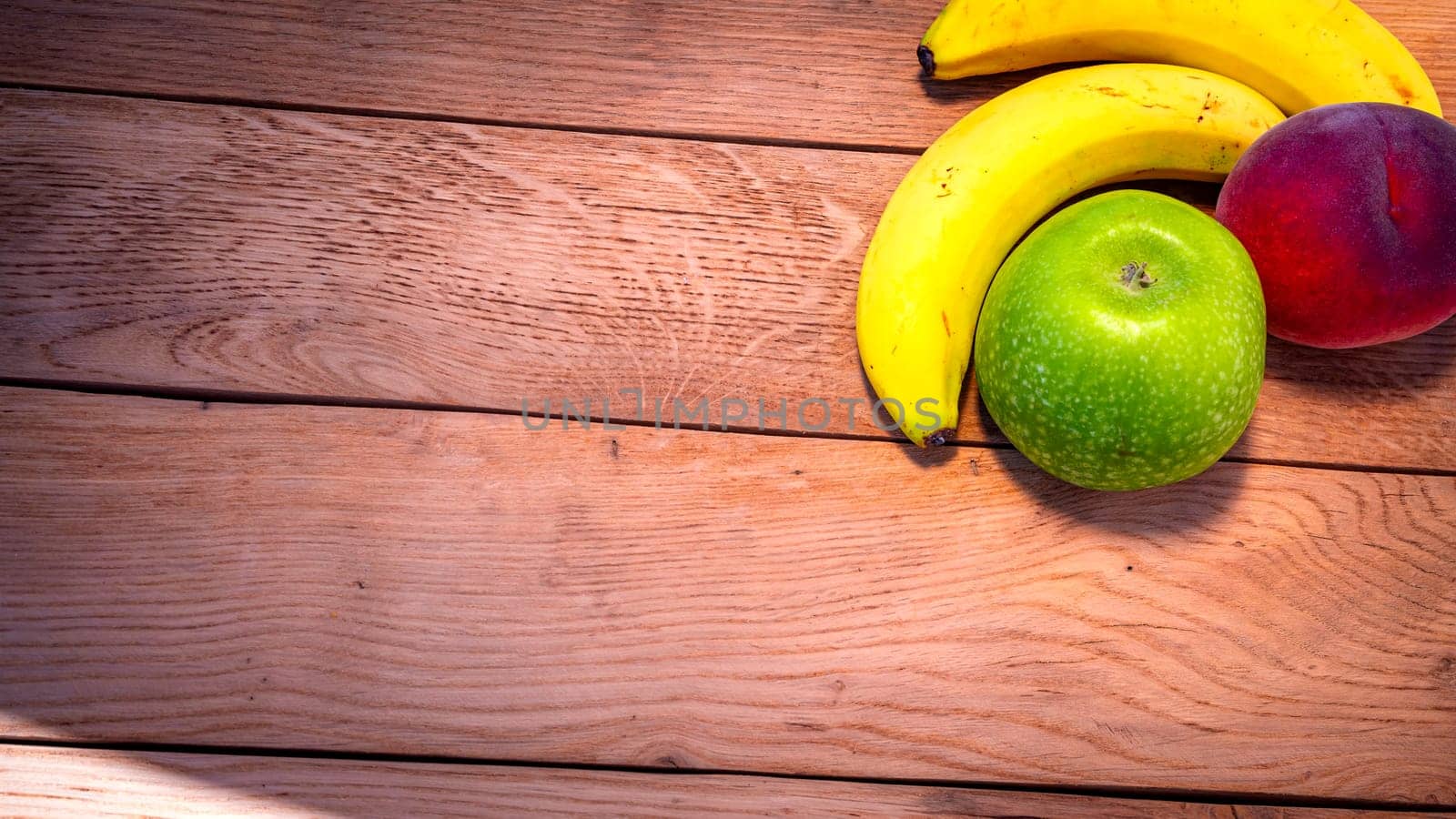 Apple, peach and bananas on a wooden board. Composition of healty fruits.