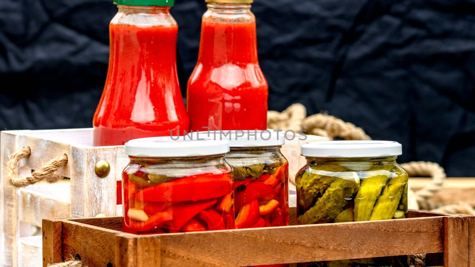 Bottles of tomato sauce, preserved canned pickled food concept isolated in a rustic composition.