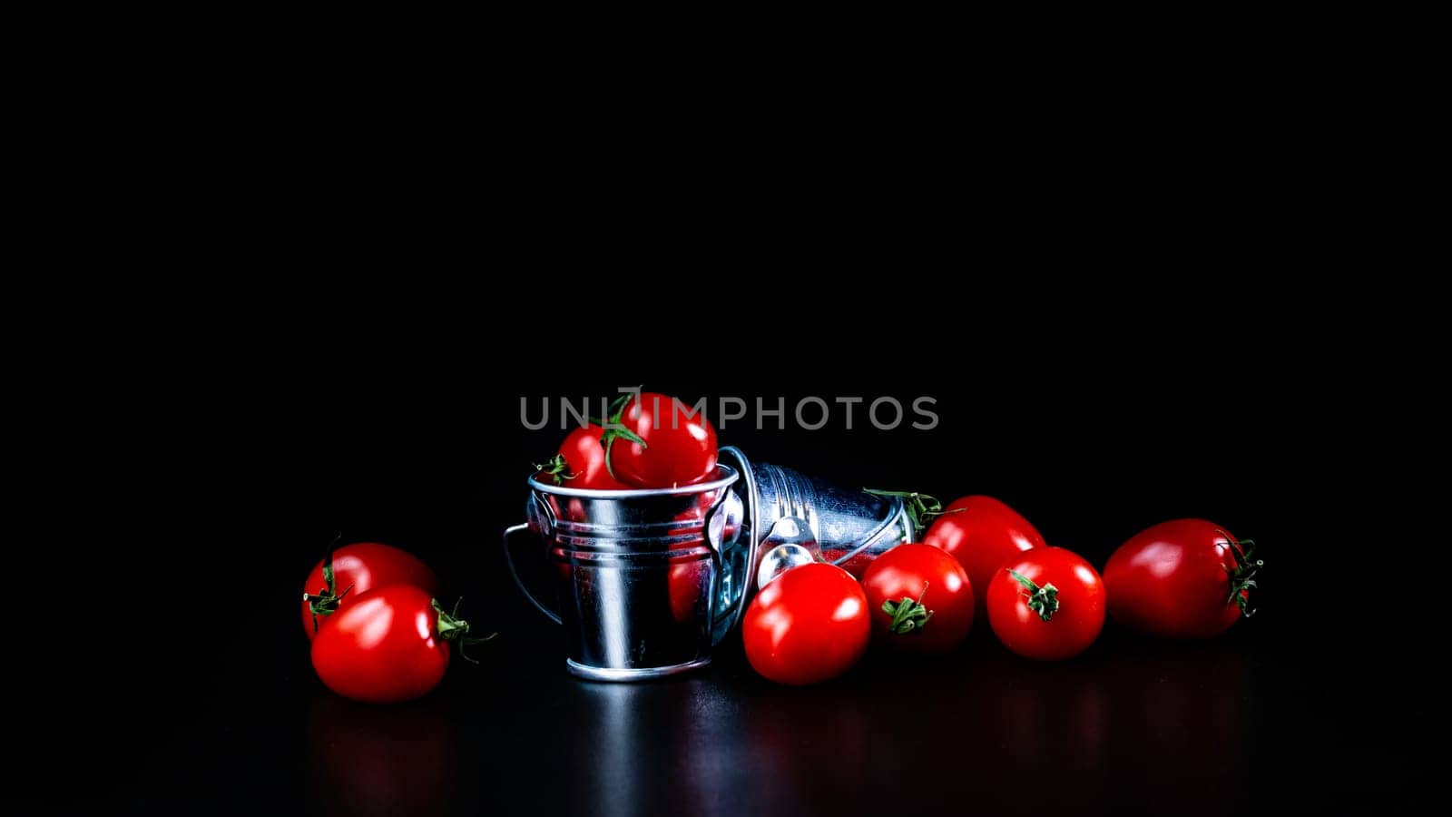 Selective focus on composition with mini decorative bucket and tomatoes. Small metal bucket with cherry tomatoes