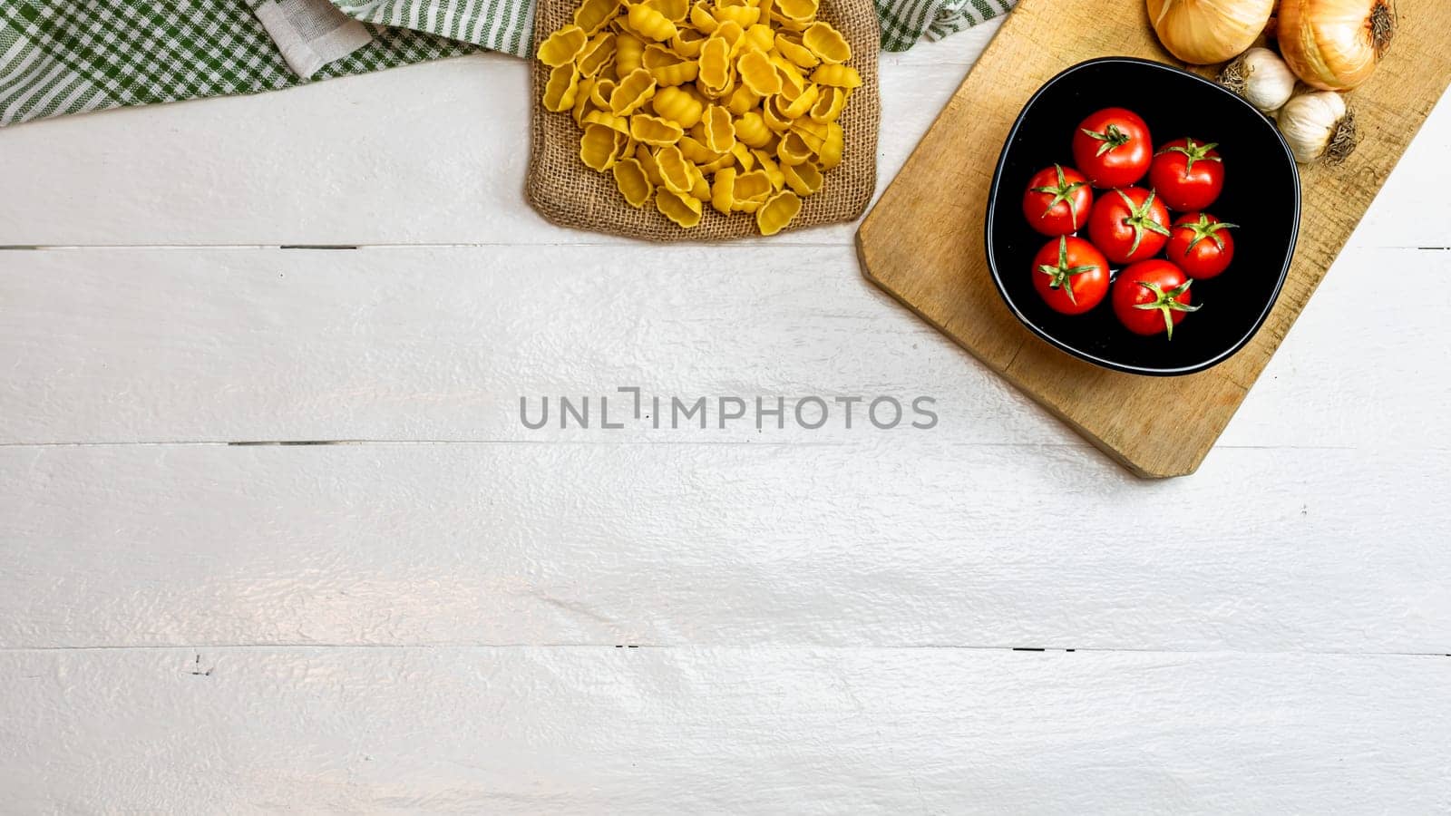 Pasta ingredients isolated. Cherry tomato, pasta, garlic and onions by vladispas