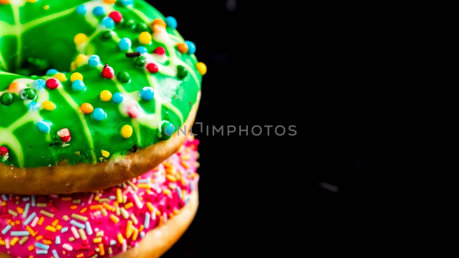 Glazed donuts with sprinkles isolated. Close up of colorful donuts.