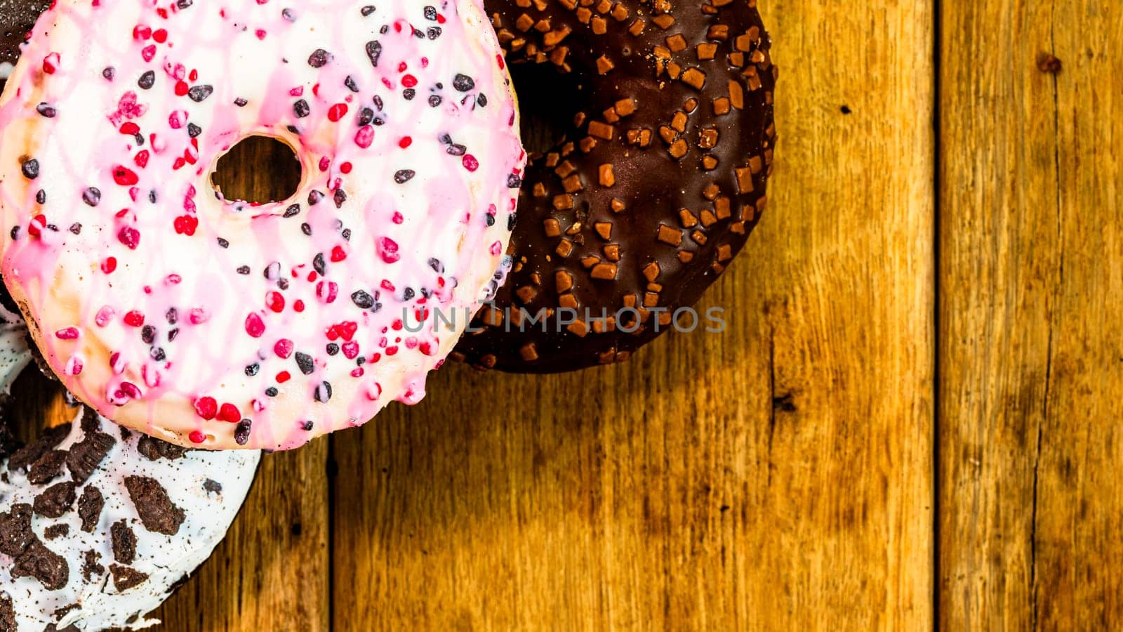 Colorful donuts on table with copy space. Top view of glazed doughnuts isolated. by vladispas