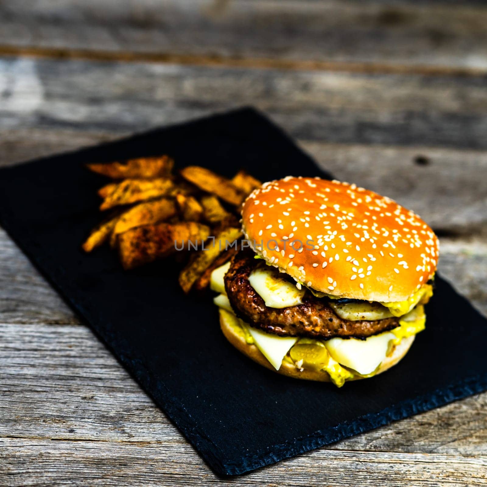 Tasty home made cheeseburger. Cheese burger with pickles, tomatoes, onion, melting cheese