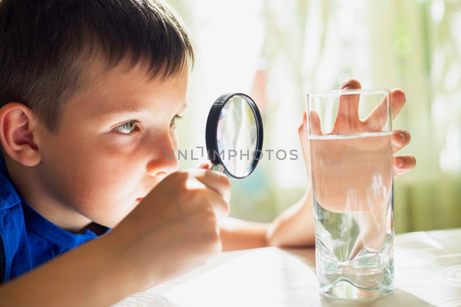 Boy Investigating Water with Magnifying Glass by andreyz