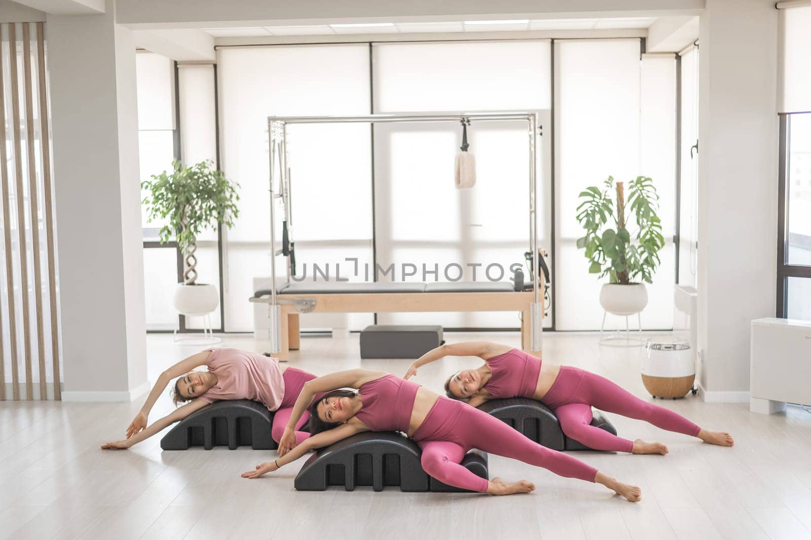 Balanced Body Pilates Arc. Three asian women exercising on pilates arc. by mrwed54