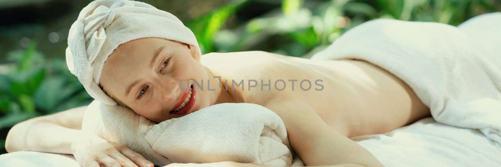 Beautiful young woman relaxes on a spa bed surrounded by nature. Tranquility by biancoblue