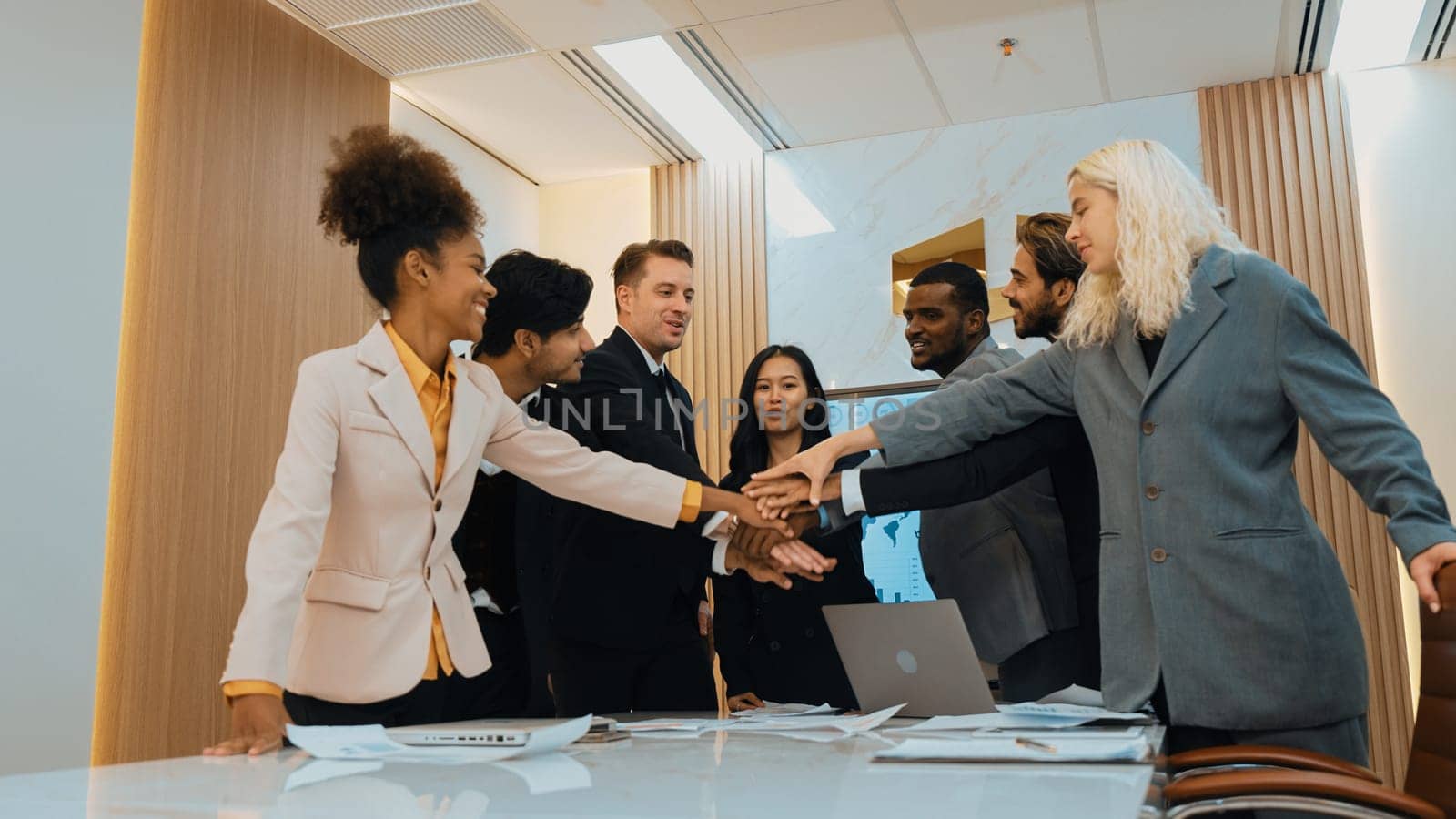 Group of diverse office worker join hand together in ornamented office room by biancoblue