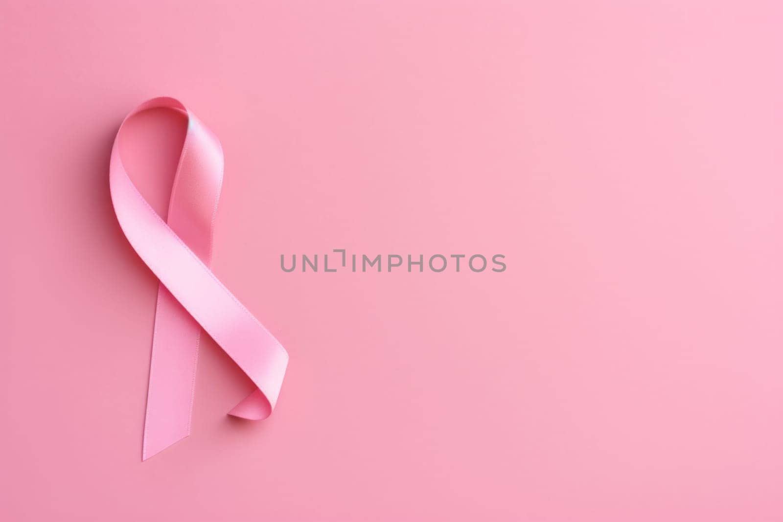 Pink cancer awareness ribbon, pink background. Generative AI.