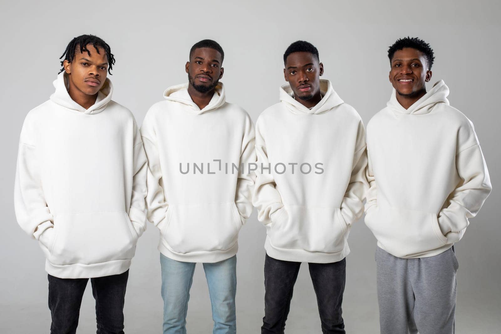 Group of African American guys in brown hoodies posing on a white background wearing sunglasses by Freeman_Studio